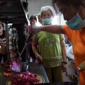 社區村民張淑惠(右)嘗試將火龍果入菜，完成火龍果雞丁